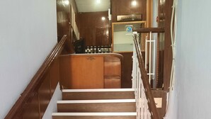 Una escalera de madera con peldaños blancos que lleva a una zona de recepción.