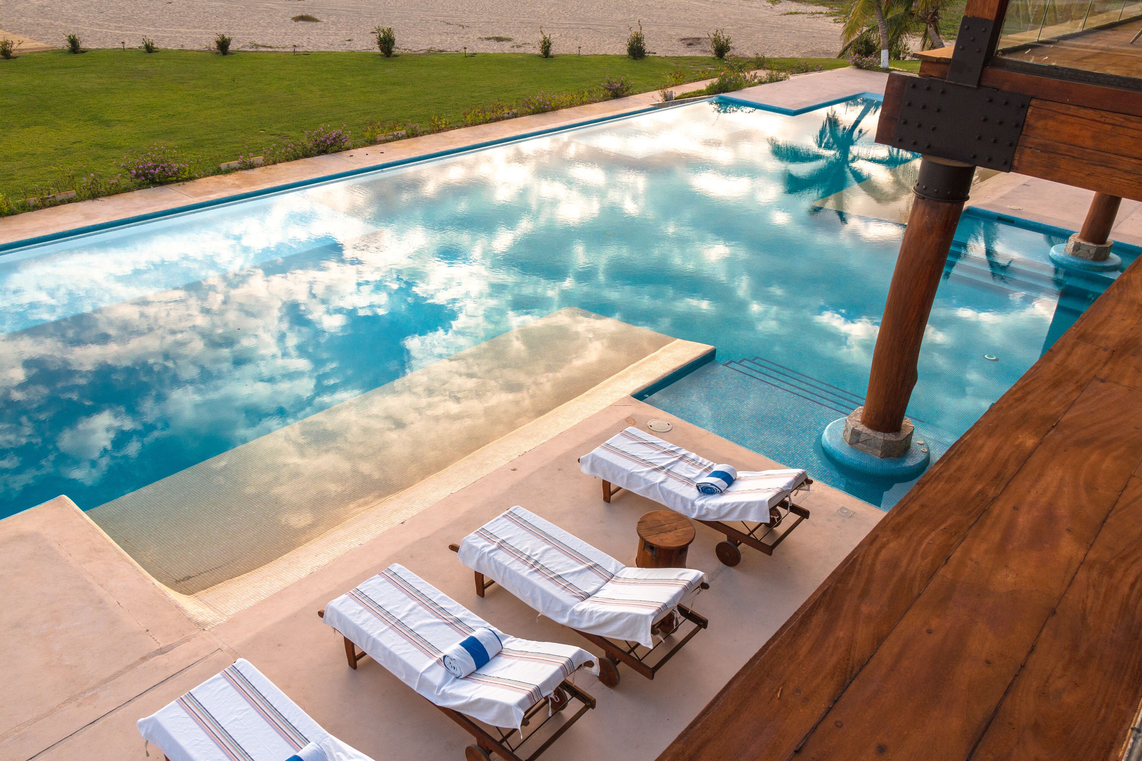 Ein Pool mit Liegestühlen und einer Holzterrasse.