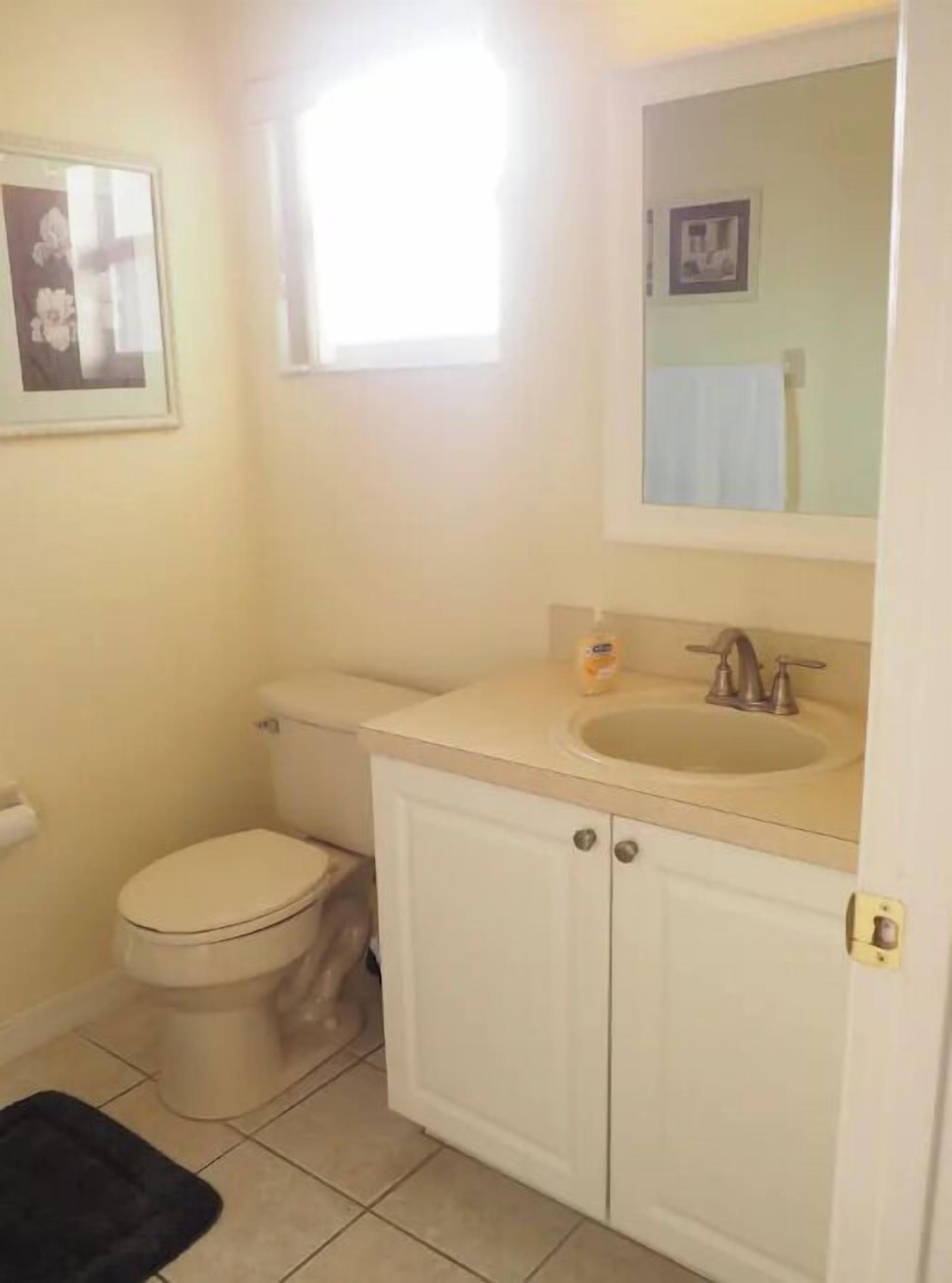 Ein kleines Badezimmer mit Toilette, Waschbecken und Schrank.