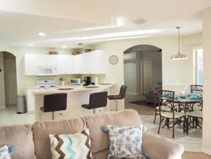 Ein modernes Wohnzimmer mit einer Couch und einem Essbereich mit Tisch und Stühlen.
