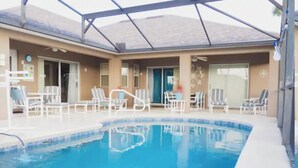 Ein Schwimmbad mit Liegestühlen und einer überdachten Terrassenanlage.