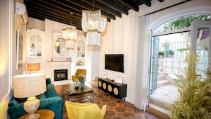 Un salon avec une cheminée, un téléviseur et un balcon donnant sur le jardin.