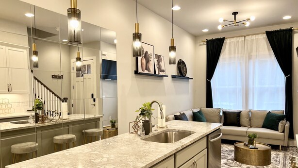 A modern kitchen with a marble countertop, stainless steel appliances, and pendant lighting. - Modern & Bright Townhouse 26th Ave (Nashville)