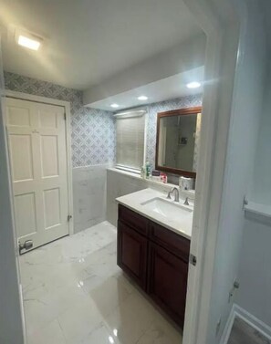 Features a bathroom with a sink, mirror, and cabinet.