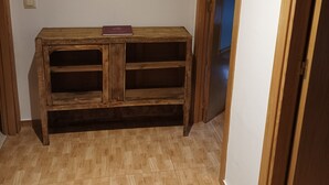 A corner room with a wooden bench, a door leading to another room, and a light switch on the wall. - The Corner of Azarrulla (Azarrulla)