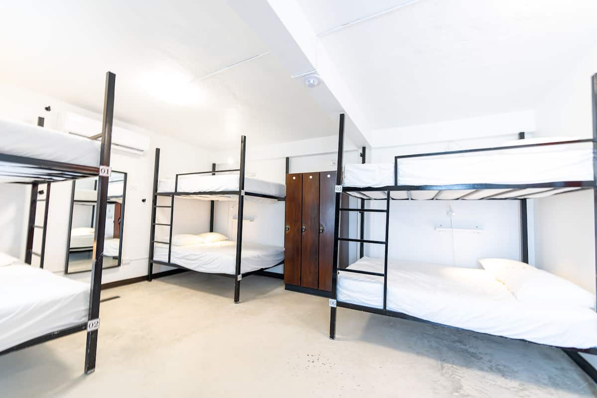 Un dormitorio con literas, un armario de madera y techo blanco.