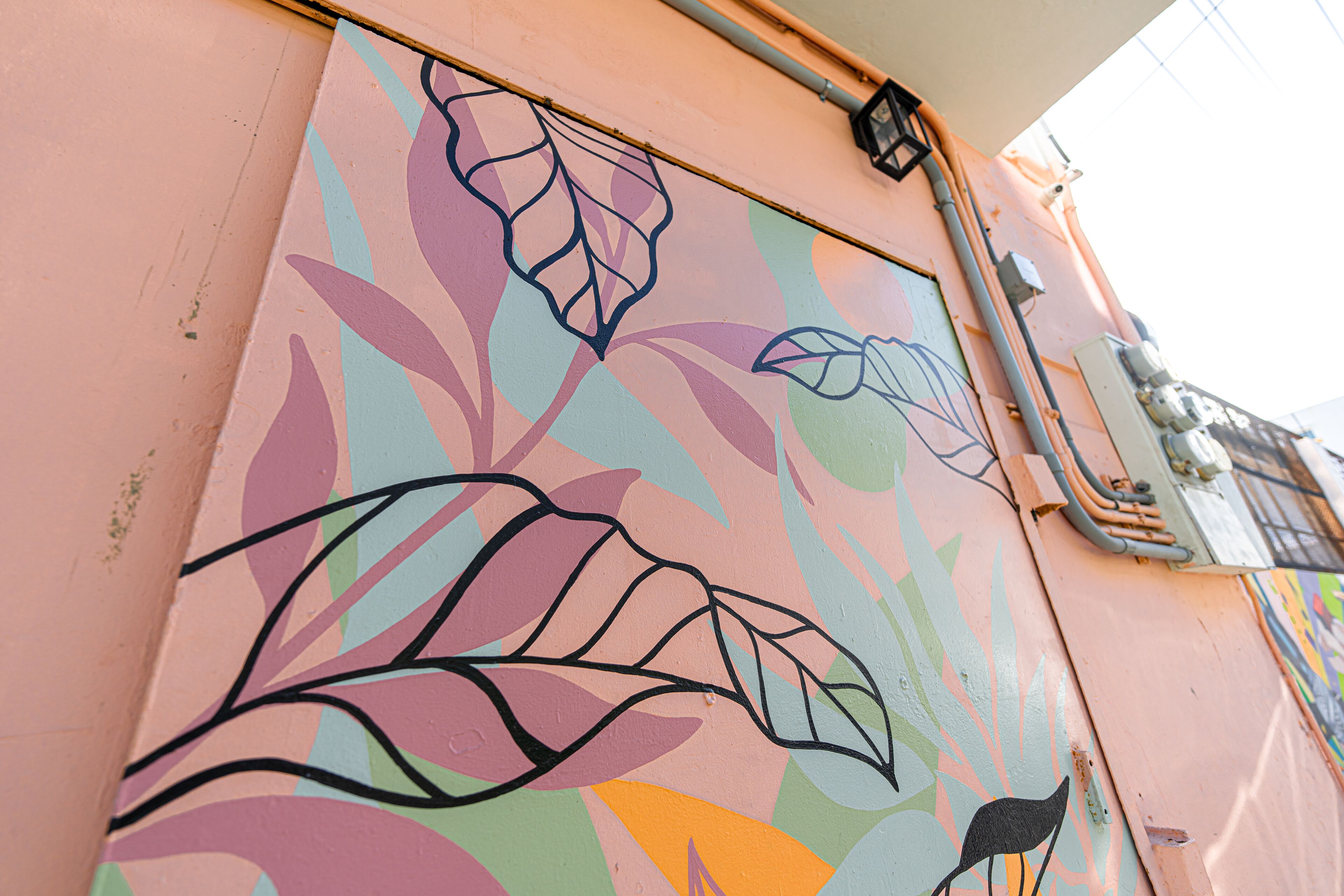 A wall with colorful abstract leaf patterns.