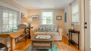 A living room with a sofa, coffee table, and a dining area with a table and chairs. - Rehoboth Beach Efficiency Downtown Deck Sleeps 2 (Rehoboth Beach)
