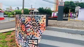 Värikäs graffitiseinä, jossa on aurinkokuva ja abstrakteja kuvioita.