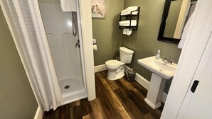 Un baño con ducha, inodoro y lavabo.