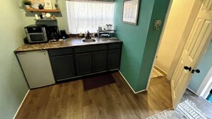 A compact kitchen with a microwave, coffee maker, and sink. - Boho Bungalow! Guesthouse near Downtown & Beaches!  (St. Petersburg)