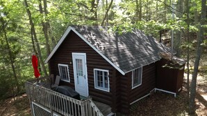 A small cabin with a porch, a door, and two windows.