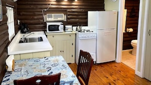 Cocina compacta con fregadero, microondas, cocina y refrigerador.