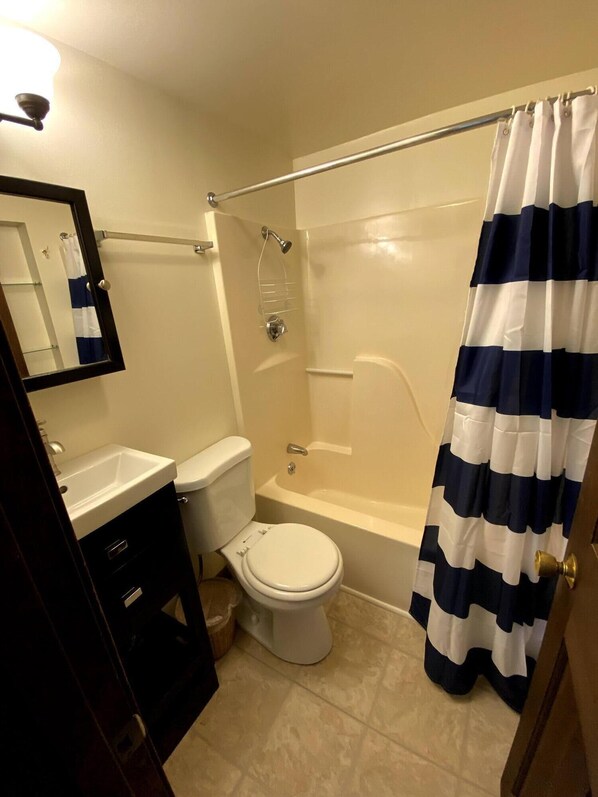 A bathroom with a toilet, sink, and bathtub.