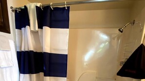 A bathroom with a shower, toilet, and sink.