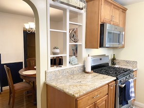 Enjoy cooking in this well-equipped kitchen with a gas range, oven, and ample cabinetry.