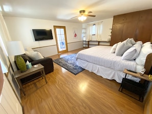 Cozy retreat with a large bed, flat-screen TV, and ceiling fan.