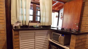 A compact kitchen with a microwave, oven, and a small countertop.