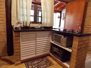 Una cocina compacta con microondas, horno y una pequeña encimera.
