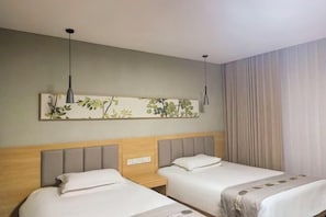 A hotel room with two beds, a nightstand, a wall-mounted artwork, and a window with curtains.