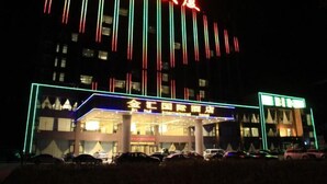 A hotel with a modern facade, illuminated by vertical neon lights.
