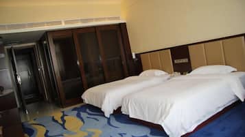 A hotel room with two beds, a large mirror, and a door leading to a hallway.