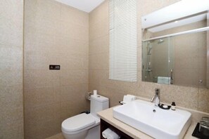 Une salle de bain avec des toilettes, un lavabo et une douche.