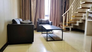 Una sala de estar moderna con un sofá, una mesa de centro y una escalera.