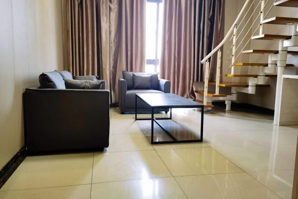 Uma sala de estar moderna com um sofá, uma mesa de centro e uma escada.
