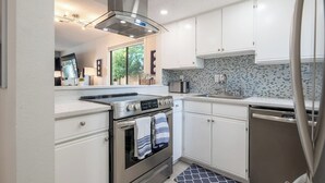 A modern kitchen with white cabinets, a stainless steel range, a built-in oven, a microwave, and a dishwasher. - 1/2 Mile to Beach, 2 bedroom townhome close to Mayo Clinic (Jacksonville Beach)