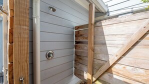 A corner of a building with wooden siding and a metal door. - 1/2 Mile to Beach, 2 bedroom townhome close to Mayo Clinic (Jacksonville Beach)