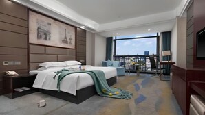 Una habitación de hotel moderna con una cama grande, un escritorio, una silla, un balcón con vistas y un cuadro de la Torre Eiffel.