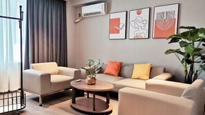 A modern living room with a sofa set, a coffee table, and a large plant. - Jinjiang Inn Select (Yangzhong Middle Yangzi Road) (Yangzhong)