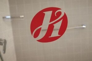 A red logo on a tiled wall. - Jinjiang Inn Select (Yangzhong Middle Yangzi Road) (Yangzhong)