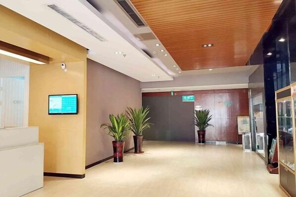 A modern lobby with a wooden ceiling, a reception desk, and potted plants. - Jinjiang Inn Select (Yangzhong Middle Yangzi Road) (Yangzhong)