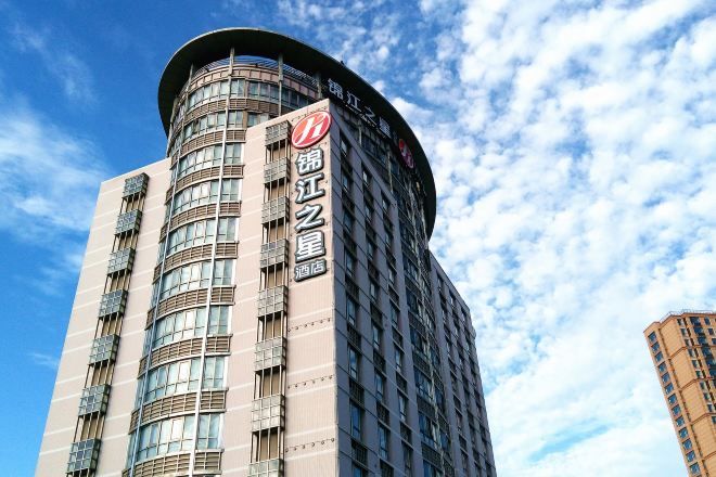 A tall hotel with a curved facade and a prominent sign.
