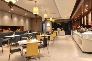 Un interior de restaurante con cabinas, mesas y una zona de bar.