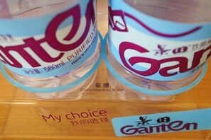 Dos botellas de agua con etiqueta 'Ganten', tapadera azul y etiqueta que indica '560ml AGUA PURIFICADA'.