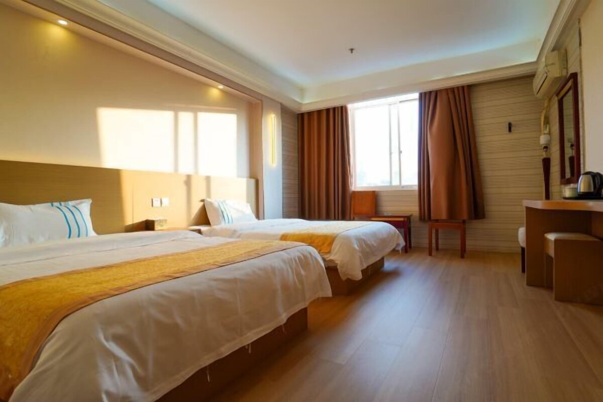 Una habitación de hotel con dos camas, un escritorio y una silla.