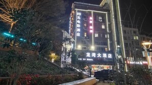 A hotel with illuminated signage, a visible entrance, and a staircase leading to the entrance. - Weishidun Hotel (Minqing)