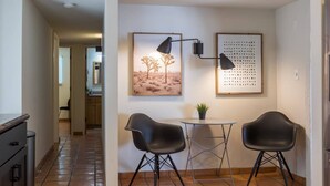 A modern kitchen with a tiled backsplash, a small dining table with two chairs, and a wall-mounted lamp. - Spacious Arcadia Lite house w/ pool, mtn. views (Phoenix)