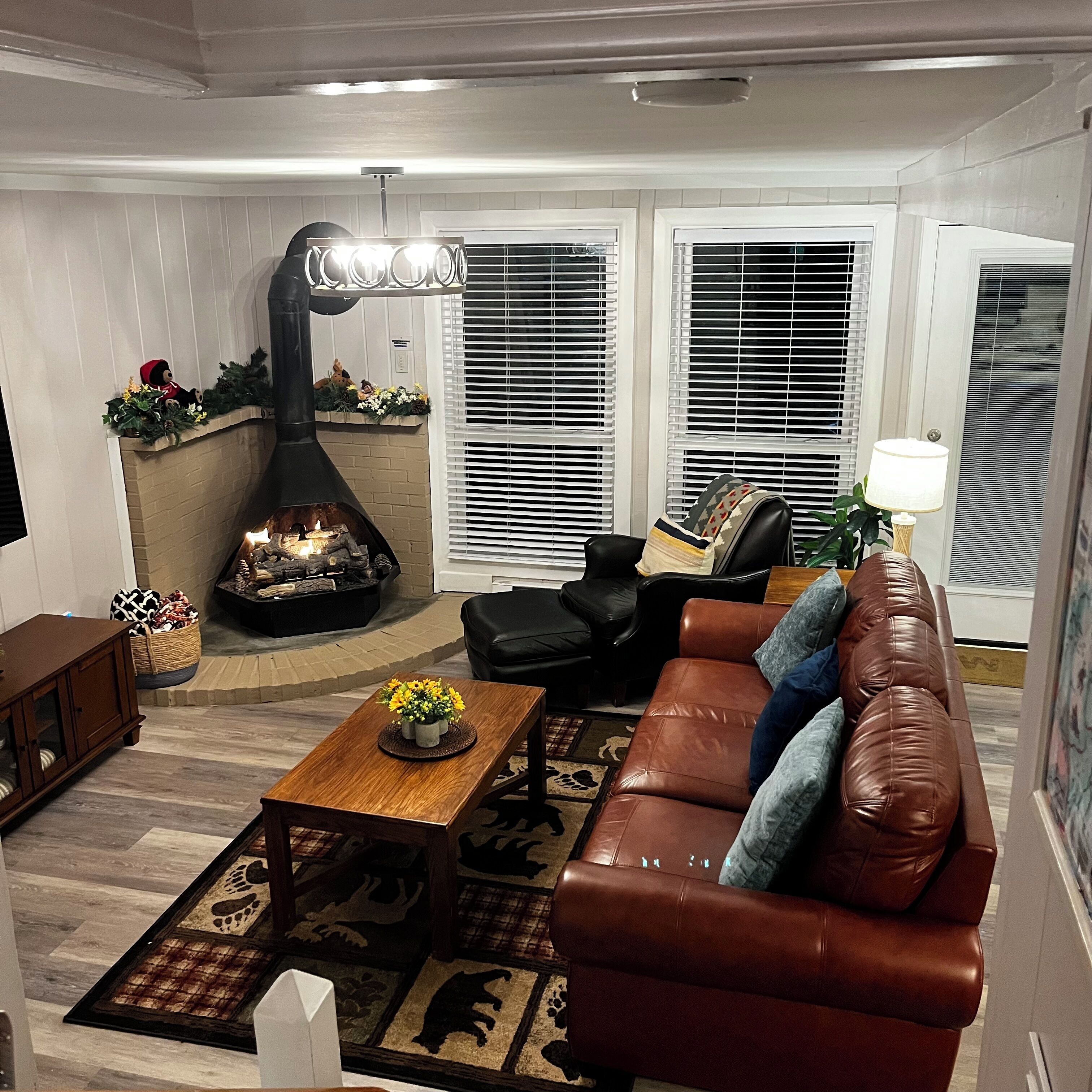Ein Wohnzimmer mit Kamin, Ledersofa und Couchtisch.
