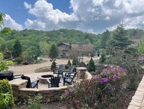 Relax in a serene outdoor space with a fire pit surrounded by Adirondack chairs.