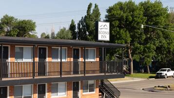 A two-story brick building with a balcony, a sign reading "Econo Inn," and a street view with a parked car.