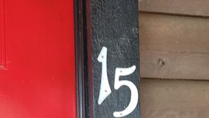 A red door with a black frame and the number 15 painted on it. - #15 Off the Hook-Uncertain Lodge and Inn (Karnack)