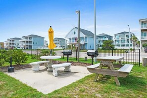 A residential area with houses, a picnic table, benches, and mailboxes. - Beach D-ehs by Brunswick Vacation Rentals: Oceanfront Condo with Pool on OIB (Ocean Isle Beach)
