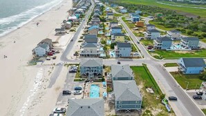 Eine Wohngegend an der Küste mit Häusern, einem Strand und einer Straße.