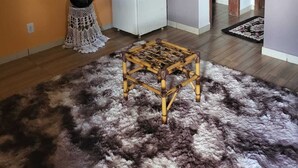 Une pièce avec un réfrigérateur blanc, une petite table et une plante en pot.