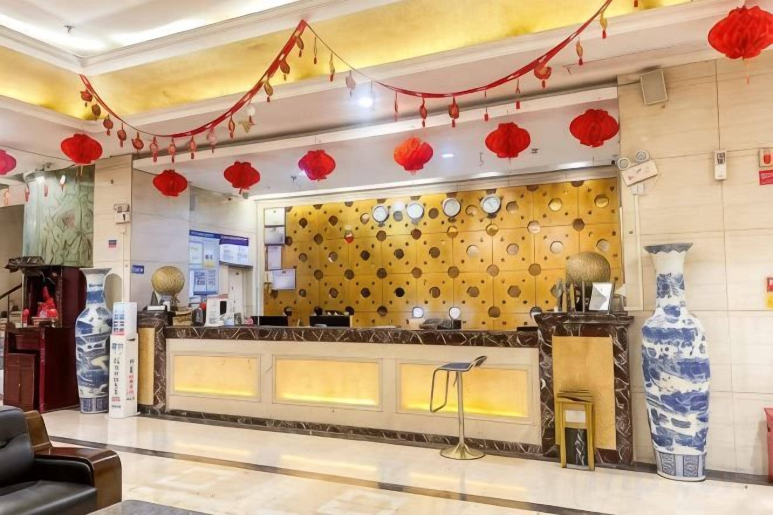 A hotel reception area with a counter, chairs, and decorative elements.
