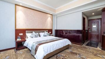 Una habitación de hotel con una cama grande, una mesita de noche, un cabecero de madera y piso alfombrado.